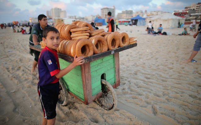 Des jeunes enfants qui vendent du pain sur la plage de Gaza le 13 juin 2015 dans la ville de Gaza (Crédit : Christopher Furlong / Getty Images via JTA),