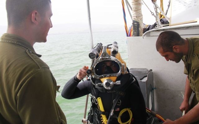 Le caporal Sahar Nitzan vérifie son équipement avant de plonger dans la mer de Galilée à la recherche du pilote disparu, le lieutenant Yakir Naveh, dont l'avion s'est écrasé en 1962, le 6 avril 2016. (Judah Ari Gross/Times of Israel)