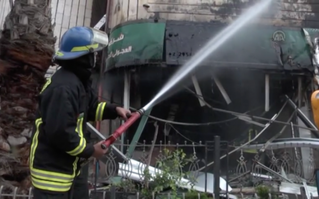 Les pompiers palestiniens éteignent un incendie dans un bureau de change de Ramallah qui s'est déclenché quand des soldats israéliens ont tenté d'ouvrir un coffre avec une explosion "contrôlée", le 14 avril 2016. (Crédit : capture d'écran YouTube) Les pompiers palestiniens éteignent un incendie dans un bureau de change de Ramallah qui s'est déclenché quand des soldats israéliens ont tenté d'ouvrir un coffre avec une explosion "contrôlée", le 14 avril 2016. (Crédit : capture d'écran YouTube)