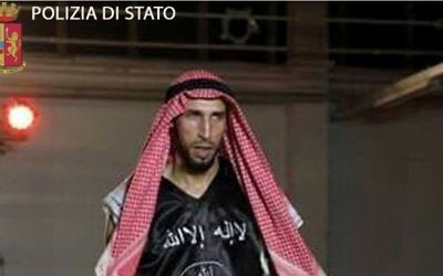 Dans une image rendue publique le 28 avril 2016, par la police italienne, Abderrahim Moutaharrik est vu portant des gants de boxe, un short, un keffieh et une chemise noire avec le drapeau de l'État islamique. (Crédit : Police italienne)