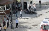 Des policiers étudient les débris devant le siège de la police à Gaziantep, une ville du sud est de la Turquie, après un attentat le 1er mai 2016. (Crédit : AFP/Ilhas News Agency)
