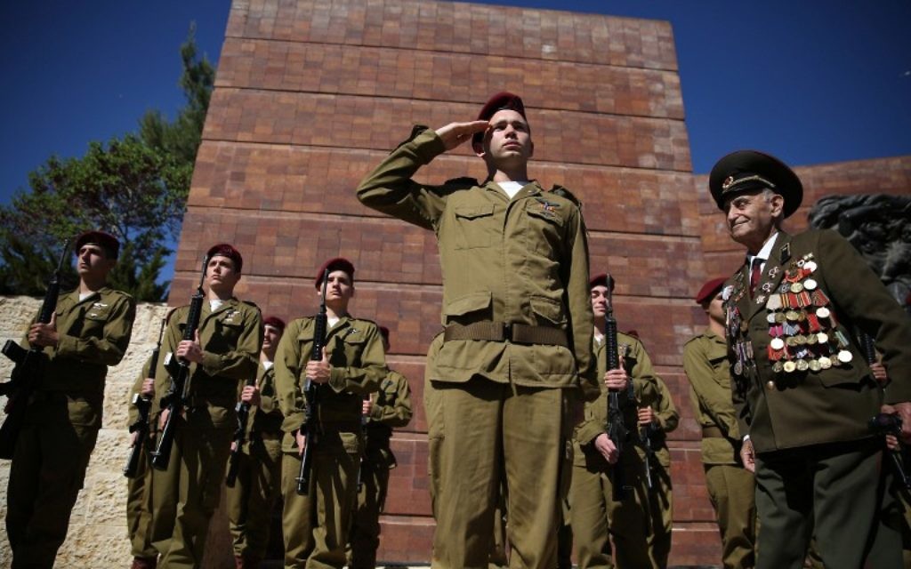 Un vétéran de la Seconde guerre mondiale passe devant une garde d'honneur formée par des soldats israéliens pendant la cérémonie du jour du souvenir de la Shoah à Yad Vashem, le 5 mai 2016 à Jérusalem. (Crédits : AFP / Gali Tibbon) Un vétéran de la Seconde guerre mondiale passe devant une garde d'honneur formée par des soldats israéliens pendant la cérémonie du jour du souvenir de la Shoah à Yad Vashem, le 5 mai 2016 à Jérusalem. (Crédits : AFP / Gali Tibbon)