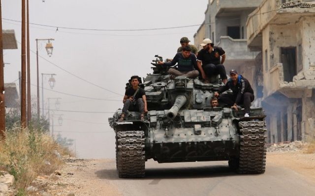 Les combattants de l'opposition conduisant un char dans une zone tenue par les rebelles de la ville syrienne de Daraa, lors de nouveaux affrontements avec des partisans du régime le 10 mai 2016 (Crédit : AFP Photo / Mohamed Abazeed) Les combattants de l'opposition conduisant un char dans une zone tenue par les rebelles de la ville syrienne de Daraa, lors de nouveaux affrontements avec des partisans du régime le 10 mai 2016 (Crédit : AFP Photo / Mohamed Abazeed)