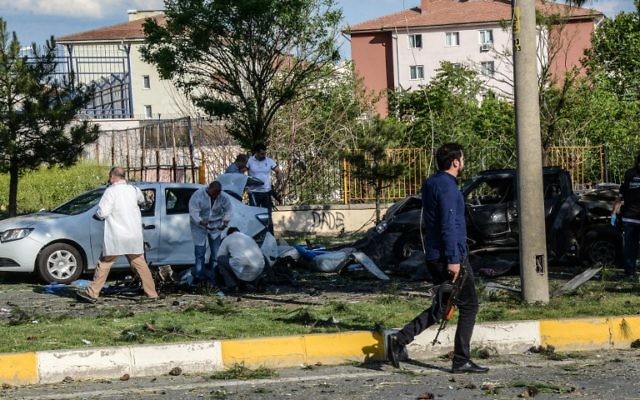 Les voitures endommagées sont examinées par la police scientifique sur le site où une bombe a explosé le 10 mai 2016 à Diyarbakir (Crédit : AFP PHOTO / ILYAS AKENGIN)