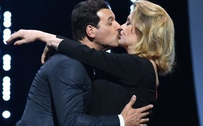Catherine Deneuve embrasse Laurent Lafitte le 11 mai 2016, à l'ouverture du 69e festival de Cannes. (Crédit : AFP / ALBERTO PIZZOLI)