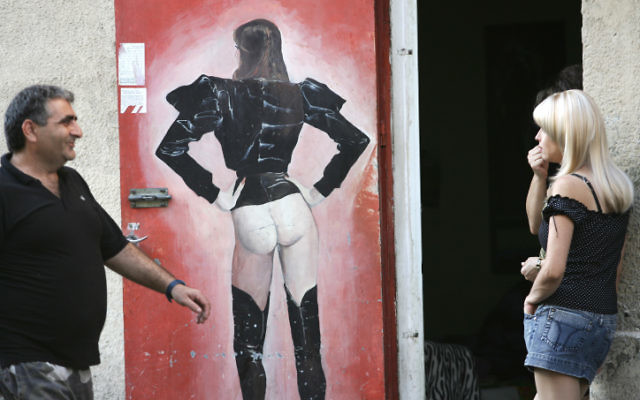 Un homme souriant à une jeune femme devant une maison close de Tel Aviv, le 21 septembre 2008. (Crédit : Kobi Gideon/Flash90)