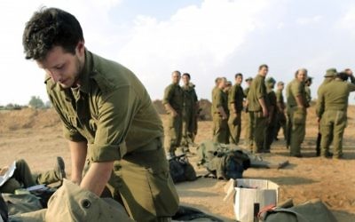 Un soldat israélien  fait son sac avant de quitter une zone de déploiement près de la frontière de la bande de Gaza, en novembre 2012. (Crédit : Tsafrir Abayov/Flash90)