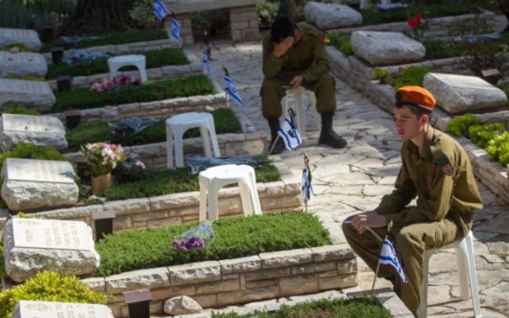 Soldats israéliens en deuil sur les tombes des soldats tombés au cimetière militaire du mont Herzl, à Jérusalem, le Jour du Souvenir, le 11 mai 2016. (Crédit : Miriam Alster/Flash90)