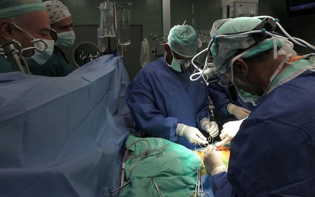 Des docteurs réalisent une chirurgie sur un patient au centre médical Wolfson à Holon (Crédit : Nati Shohat/Flash90)