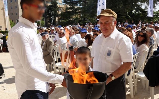 Le président de l'Agence juive Natan Sharansky allumant une flamme commémorative avec deux membres de la famille d'un Juif du Yemen, Moshe Nahari. (Les visages ont été floutés à la demande de la famille), le 11 mai 2016 (Crédit : Sasson Tiram pour l'Agence juive pour Israël)