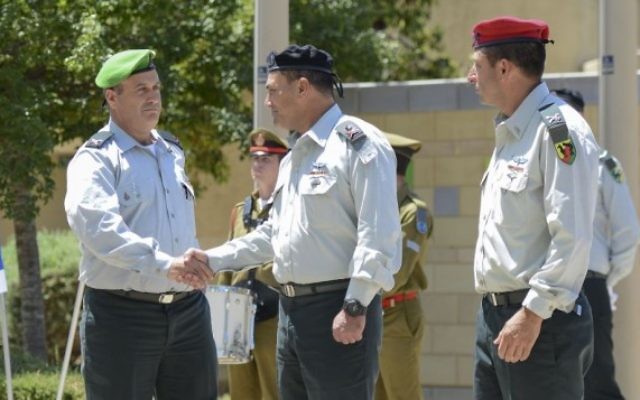 Le nouveau chef de la Division de Gaza, le Brigadier général Yehuda Fuchs, à gauche, serre la main au chef du Commandement Sud, le général Eyal Zamir au cours de la cérémonie de sortie du Brigadier général Itay Virov, à droite, à la base de la Division, près de la frontière de Gaza, le 19 mai 2016 (Crédit unité du porte-parole de Tsahal)