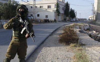 Un soldat israélien à l'entrée du village palestinien de Yatta, près de Hébron, en Cisjordanie, le 9 juin 2016. (Crédit : AFP/HAZEM BADE)