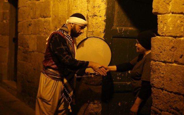 Michel Ayoub, arabe israélien chrétien, assume la fonction de messaharati, chargé de réveiller les musulmans pendant le Ramadan pour le souhour, le repas qui précède l'aube, à Saint-Jean d'Acre, le 16 juin 2016. (Crédit : AFP/Ahmad Gharabli) Michel Ayoub, arabe israélien chrétien, assume la fonction de messaharati, chargé de réveiller les musulmans pendant le Ramadan pour le souhour, le repas qui précède l'aube, à Saint-Jean d'Acre, le 16 juin 2016. (Crédit : AFP/Ahmad Gharabli)