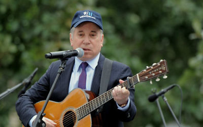 Photo d'archives prise le 11 septembre 2011 montrant le chanteur Paul Simon en train de jouer “Sounds of Silence” à l'occasion du 10e anniversaire de commémoration du 11 septembre 2001 (Crédit : Stan Honda/AFP)
