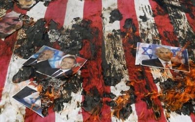 Portrait du roi de Bahreïn Hamad (en haut à gauche), du Premier ministre israélien Benjamin Netanyahu et du président turc Recep Tayyip Erdogan sur un drapeau américain en flammes pendant une manifestation de la Journée al-Quds [Jérusalem] à Téhéran, le 1er juillet 2016. (Crédit : Atta Kenare/AFP)
