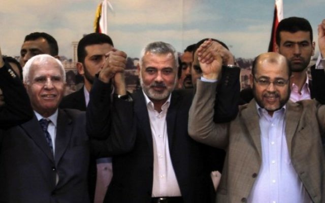 (de gauche à droite) Le chef de la délégation du Fatah Azzam al-Ahmad, le Premier ministre du Hamas dans la bande Gaza Ismail Haniyeh et l'adjoint du chef politique du Hamas Moussa Abu Marzouk après un accord entre les dirigeants de la Cisjordanie et de la bande de Gaza pour la formation d'un gouvernement d'unité sous cinq semaines, à Gaza Ville, le 23 avril 2014. (Crédit : AFP/Said Khatib) (de gauche à droite) Le chef de la délégation du Fatah Azzam al-Ahmad, le Premier ministre du Hamas dans la bande Gaza Ismail Haniyeh et l'adjoint du chef politique du Hamas Moussa Abu Marzouk après un accord entre les dirigeants de la Cisjordanie et de la bande de Gaza pour la formation d'un gouvernement d'unité sous cinq semaines, à Gaza Ville, le 23 avril 2014. (Crédit : AFP/Said Khatib)