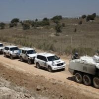 Un convoi de la Force des Nations unies chargée d'observer le dégagement (FNUOD) quitte le côté syrien du plateau du Golan pour Israël, le  15 septembre 2014. (Crédit : AFP/Jalaa Marey)