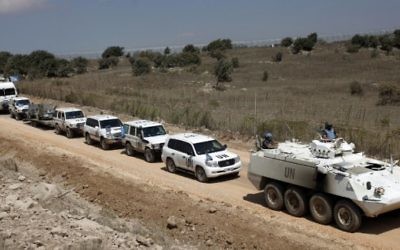 Un convoi de la Force des Nations unies chargée d'observer le dégagement (FNUOD) quitte le côté syrien du plateau du Golan pour Israël, le  15 septembre 2014. (Crédit : AFP/Jalaa Marey)