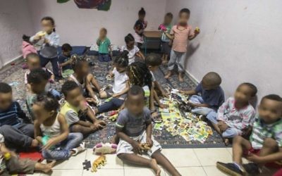 Des enfants de familles de migrants africains rassemblées dans une "crèche" dans le sud de Tel Aviv, le 28 mai 2015. Caractérisée par une saleté et une misère noire, elles ont toutes été dénoncées par des associations de défense des droits de l'Homme et les médias comme des "entrepôts à bébé". Les visages des enfants ont été floutés pour protéger leurs identités. (Crédit : AFP/Jack Guez)