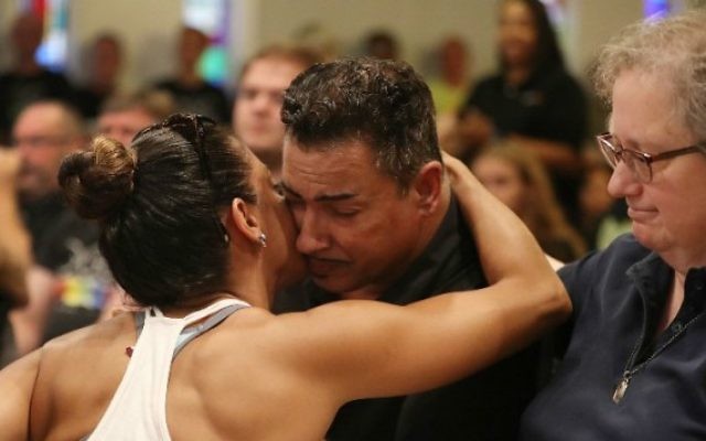 Une femme prend dans ses bras un homme blessé par la fusillade au Pulse pendant un service en mémoire des victimes de l'attentat terroriste à l'église Joy MCC à Orlando, en Floride, le 12 juin 2016. (Crédit : Joe Raedle/Getty Images/AFP) Une femme prend dans ses bras un homme blessé par la fusillade au Pulse pendant un service en mémoire des victimes de l'attentat terroriste à l'église Joy MCC à Orlando, en Floride, le 12 juin 2016. (Crédit : Joe Raedle/Getty Images/AFP)