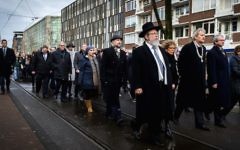 le maire d'Amsterdam Eberhard van der Laan (4e à droite) pendant une marche entre la mairie et le monument d’Auschwitz au parc Wertheimpark d'Amsterdam le 26 janvier 2014, pendant la Journée nationale du souvenir des victimes de l'Holocauste. (Crédit : AFP Photo/ANP/Remko de Waal via JTA)