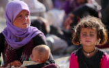 Une femme yazidie irakienne assise avec ses enfants au camp Bajid Kandala près du fleuve du Tigre, dans la province de Dohouk à l'ouest du Kurdistan, où ils ont trouvé refuge après avoir fui les avancées par les terroristes de l'État islamique en Irak, le 13 août 2014. (Crédit : Ahmad Al-Rubaye/AFP)