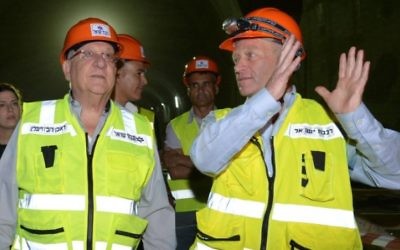 Le président Reuven Rivlin, à gauche, avec le directeur du projet Fast Lane vers Jérusalem, Dror Sofro, pendant une visite du chantier du train à haute vitesse entre Tel Aviv et Jérusalem, le 1er juin 2016. (Crédit : Mark Neyman/GPO)