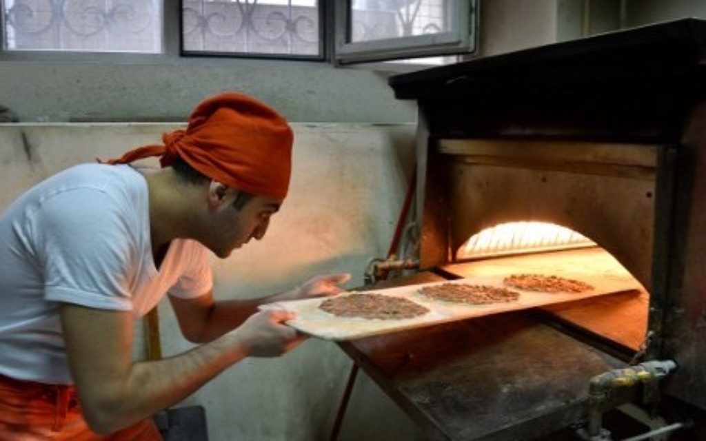 Kaits Jabakhchuryan prépare du lahmajoon (un pain fin et croustillant, recouvert de viande hachée) dans son restaurant à Erevan, le 31 mars 2016. (Crédits : AFP Photo / Karen Minasyan)
