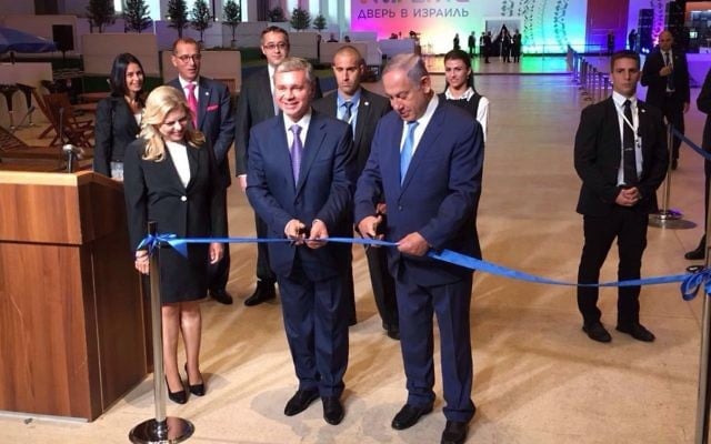 Le Premier ministre Benjamin Netanyahu (à droite) inaugure avec u officiel russe l'exposition "Ouvrir une porte sur Israël" à Moscou, en présence de son épouse Sara (à gauche), le 7 juin 2016. (Crédit : Haim Zach/GPO)