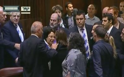 Altercation entre la députée Hanin Zoabi de la Liste arabe unie, au centre, et d'autres élus en séance plénière de la Knesset après son discours sur l'accord de réconciliation entre Israël et la Turquie, le 29 juin 2016. (Crédit : capture d'écran Chaîne de la Knesset)