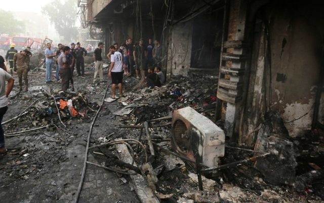 Des Irakiens inspectent les dégâts après une attaque à la voiture piégée revendiquée par l'Etat islamique qui a fait de nombreux morts dans le quartier central de Karrada, à Bagdad, le 3 juillet 2016 (Crédit : Sabah Arar/AFP) Des Irakiens inspectent les dégâts après une attaque à la voiture piégée revendiquée par l'Etat islamique qui a fait de nombreux morts dans le quartier central de Karrada, à Bagdad, le 3 juillet 2016 (Crédit : Sabah Arar/AFP)