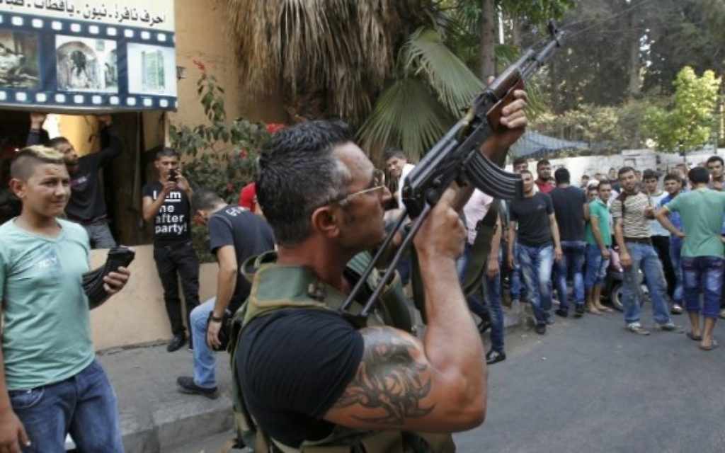 Un Libanais armé pendant la procession funéraire de Hamad al-Moqdad, une des victimes libanaises d'un attentat à la voiture piégée qui a tué des dizaines de personnes dans un bastion du Hezbollah à Beyrouth, le 16 août 2013. (Crédit : AFP/Anwar Amro)