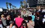Les gens déposent des fleurs, des bougies et des messages à un mémorial improvisé à Nice le 16 juillet 2016, en hommage aux victimes de l'attaque du 14 juillet sur la promenade des Anglais, qui a tué au moins 84 personnes et fait des centaines de blessés. (Crédit : Giuseppe Cacace/AFP)