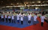 Des enfants portent des bannières portant les noms et les drapeaux des pays participant au championnat international de taekwondo à Birzeit, à Ramallah, en Cisjordanie, le 18 juillet 2016. (Crédit : AFP/Abbas Momani)