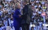 Le président américain Barack Obama rejoint la candidate démocrate à la présidentielle Hillary Clinton après son discours à la Convention nationale démocratique au Wells Fargo Center à Philadelphie, en Pennsylvanie, le 27 juillet 2016. (Crédit : Mandel Ngan/AFP)