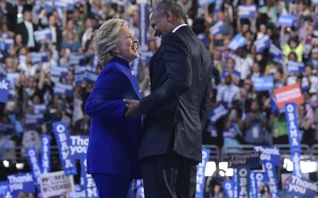 Le président américain Barack Obama rejoint la candidate démocrate à la présidentielle Hillary Clinton après son discours à la Convention nationale démocratique au Wells Fargo Center à Philadelphie, en Pennsylvanie, le 27 juillet 2016. (Crédit : Mandel Ngan/AFP)