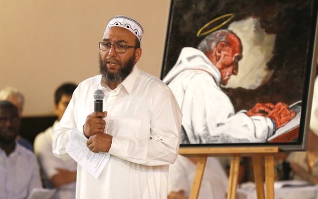 L'imam d'Oissel Abdellatif Hmito prononce un discours près d'un portrait du père Jacques Hamel, assassiné pendant une attaque terroriste, pendant une veillée en l'église Sainte-Thérèse de Saint-Etienne du Rouvray, le 30 juillet 2016. (Crédit : AFP/Charly Triballeau) L'imam d'Oissel Abdellatif Hmito prononce un discours près d'un portrait du père Jacques Hamel, assassiné pendant une attaque terroriste, pendant une veillée en l'église Sainte-Thérèse de Saint-Etienne du Rouvray, le 30 juillet 2016. (Crédit : AFP/Charly Triballeau)