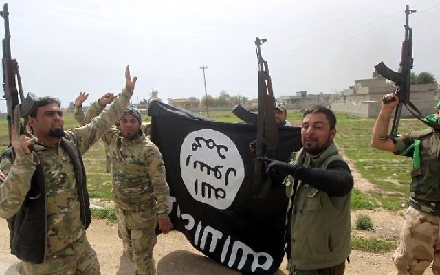 Des membres de l'unité paramilitaire irakienne Mobilisation Populaire célèbrent la reprise du village d'Albu Ajil, près de la ville de Tikrit, qui était détenu par l'Etat islamique, en agitant un drapeau du groupe terroriste, le 9 mars 2015 (Crédit : AFP/Ahmad al-Rubaye) Des membres de l'unité paramilitaire irakienne Mobilisation Populaire célèbrent la reprise du village d'Albu Ajil, près de la ville de Tikrit, qui était détenu par l'Etat islamique, en agitant un drapeau du groupe terroriste, le 9 mars 2015 (Crédit : AFP/Ahmad al-Rubaye)