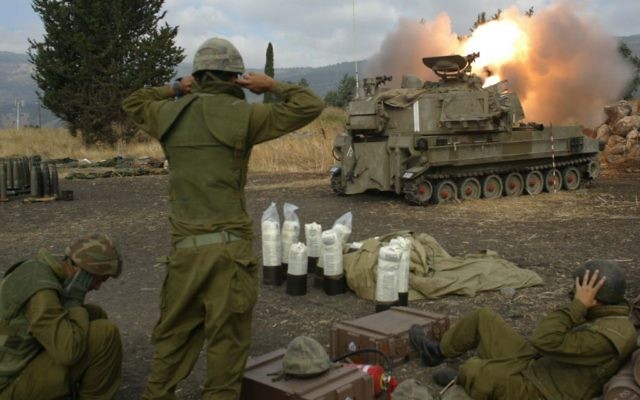 Les soldats israéliens couvrent leurs oreilles alors qu'ils tirent des obus d'artillerie dans le sud du Liban depuis l'extérieur de Kiryat Shmona, dans le nord d'Israël au cours de la seconde guerre du Liban, le 22 juillet, 2006. (Crédit : Pierre Terdjman / Flash90)