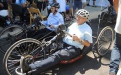 Le ministre du Tourisme Yariv Levin (à gauche) et le maire de Tel Aviv Ron Huldai essaient des handbikes sur la piste cyclable nouvellement adaptée, le 28 juillet 2016 (Crédit : Melanie Lidman/Times of Israel)