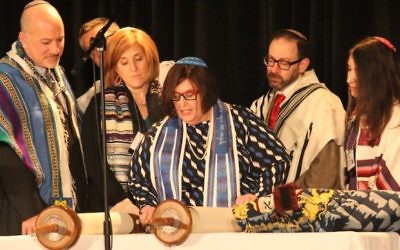 La rabbin Denise Eger, au centre, lit la Torah pendant son intronisation comme présidente de la Conférence centrale des rabbins américains, le 16 mars 2015. Illustration. (Crédit : David A.M. Wilensky)