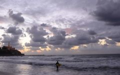 Un surfeur solitaire le long de la côte de Tel Aviv. (Crédit : Tomer Neuberg/Flash90)