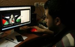 IIllustration : Un Gazaoui regarde un post pro-palestinien publié sur Facebook, le 7 avril 2013  (Crédit : Abed Rahim Khatib/Flash90)