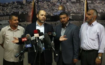 Moussa Abu Marzouk (deuxième à gauche), responsable du Hamas, s'adresse aux médias depuis le poste-frontière de Rafah, dans le sud de la bande de Gaza, après des négociations avec Le Caire, le 28 août 2014. (Crédit : Abed Rahim Khatib/Flash90)