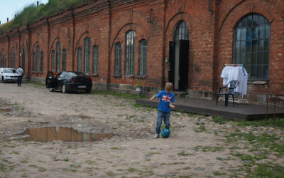 Un garçon jouant au football à l'entrée de l'ancien camp de concentration connu sous le nom de Septième Fort à Kaunas, en Lituanie, le 12 juillet 2016. (Photo : Cnaan Liphshiz)