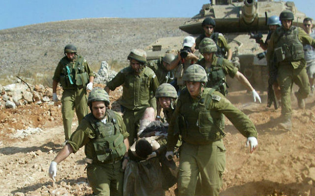Les soldats évacuant un camarade blessé au cours de la Deuxième guerre du Liban, le 24 juillet 2006. (Crédit : Haïm Azoulay/Flash 90)