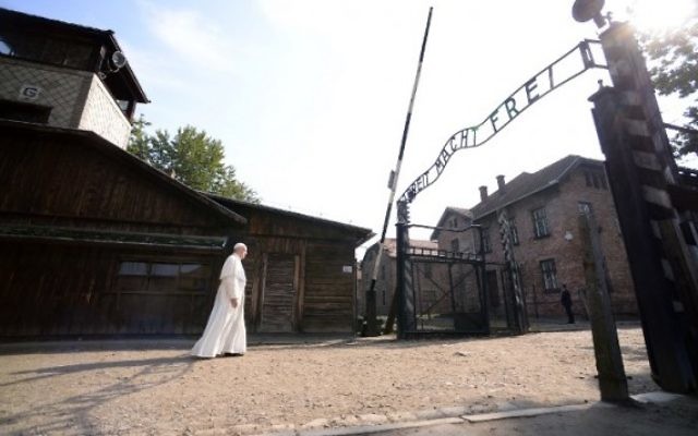 Le pape François à l’entrée principale de l’ancien camp d’extermination nazi d’Auschwitz-Birkenau, qui porte les mots "Arbeit macht frei" ("le travail rend libre"), à Oswiecim, en Pologne, le 29 juillet 2016. (Crédit : Filippo Monteforte/AFP) Le pape François à l’entrée principale de l’ancien camp d’extermination nazi d’Auschwitz-Birkenau, qui porte les mots "Arbeit macht frei" ("le travail rend libre"), à Oswiecim, en Pologne, le 29 juillet 2016. (Crédit : Filippo Monteforte/AFP)