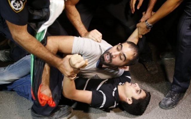 La police israélienne arrête des manifestants qui protestent contre la détention administrative du prisonnier palestinien Bilal Kayed, qui est en grève de la faim depuis 56 jours, devant l'hôpital d'Ashkelon où il est détenu, le 9 août 2016. (Crédit : AFP/Ahmad Gharabli) La police israélienne arrête des manifestants qui protestent contre la détention administrative du prisonnier palestinien Bilal Kayed, qui est en grève de la faim depuis 56 jours, devant l'hôpital d'Ashkelon où il est détenu, le 9 août 2016. (Crédit : AFP/Ahmad Gharabli)