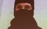 Une photo d'Aaaron Driver, fournie par la GRC, montrée sur les écrans, alors que le commissaire adjoint de la gendarmerie royale du Canada, Mike Cabana, (qui ne figure pas sur la photo) parle au cours d'une conférence de presse aux quartiers généraux de la GRC, à Ottawa, dans l'Ontario, le 11 août 2016 (Crédit : AFP/Lars Hagberg)