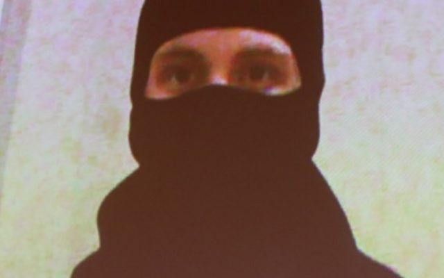 Une photo d'Aaaron Driver, fournie par la GRC, montrée sur les écrans, alors que le commissaire adjoint de la gendarmerie royale du Canada, Mike Cabana, (qui ne figure pas sur la photo) parle au cours d'une conférence de presse aux quartiers généraux de la GRC, à Ottawa, dans l'Ontario, le 11 août 2016 (Crédit : AFP/Lars Hagberg)